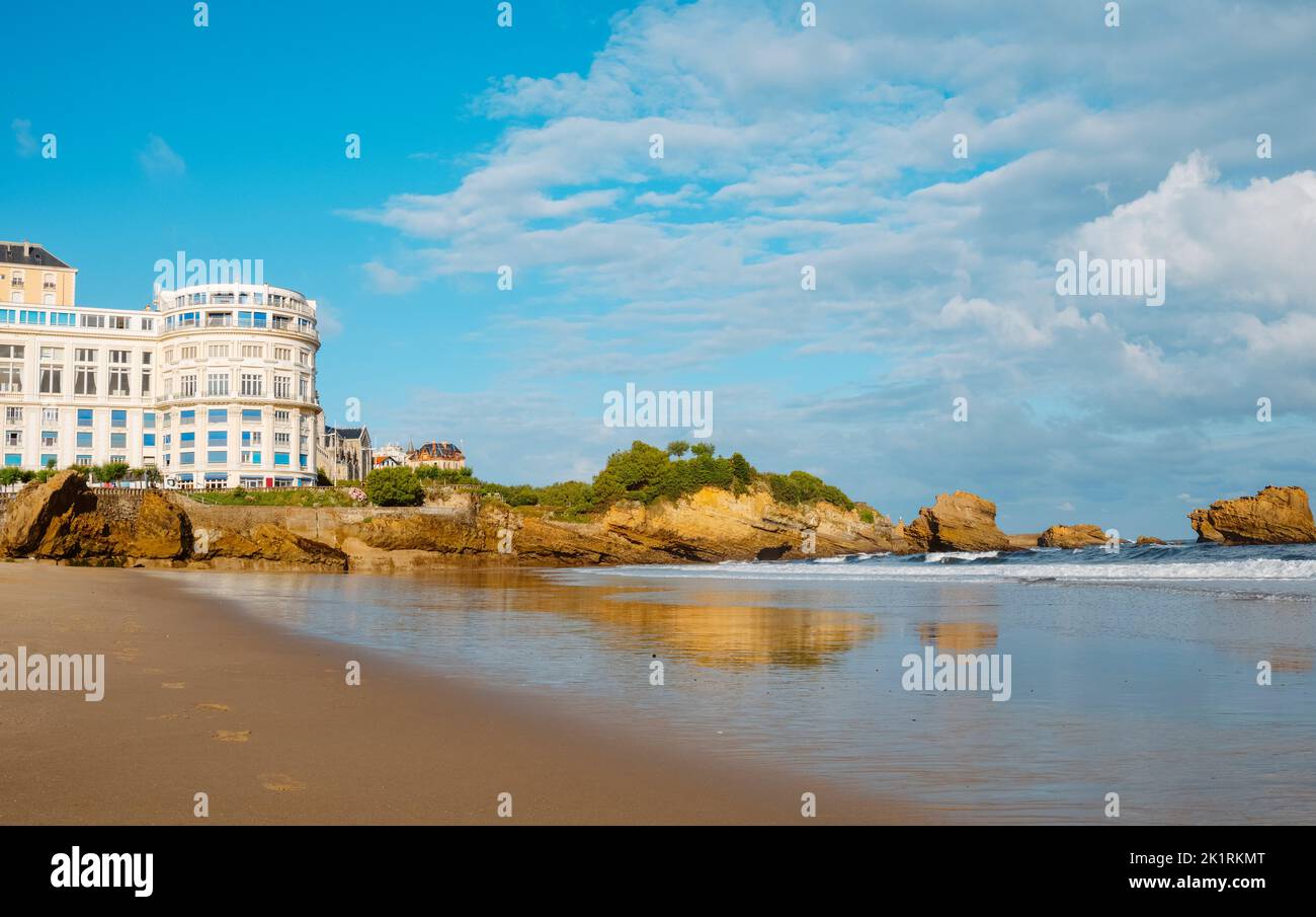 Une vue sur la plage de la Grande Plage à Biarritz, en France, avec la formation rocheuse du Rocher du Basta sur la droite, tôt le matin dans une journée d'été Banque D'Images