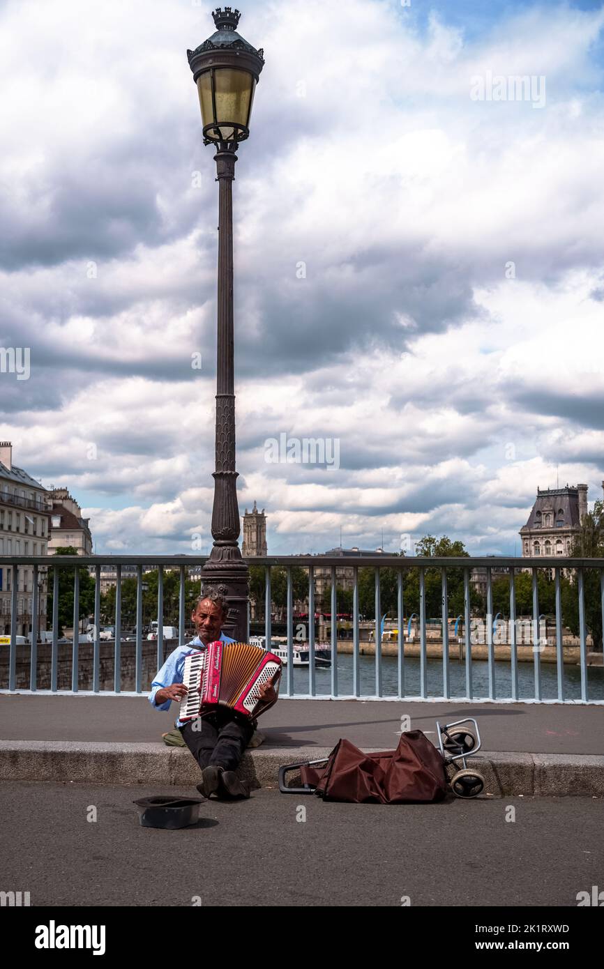 Un cliché vertical d'un musicien de rue avec un accordéon sur le pont de Tournelle Banque D'Images