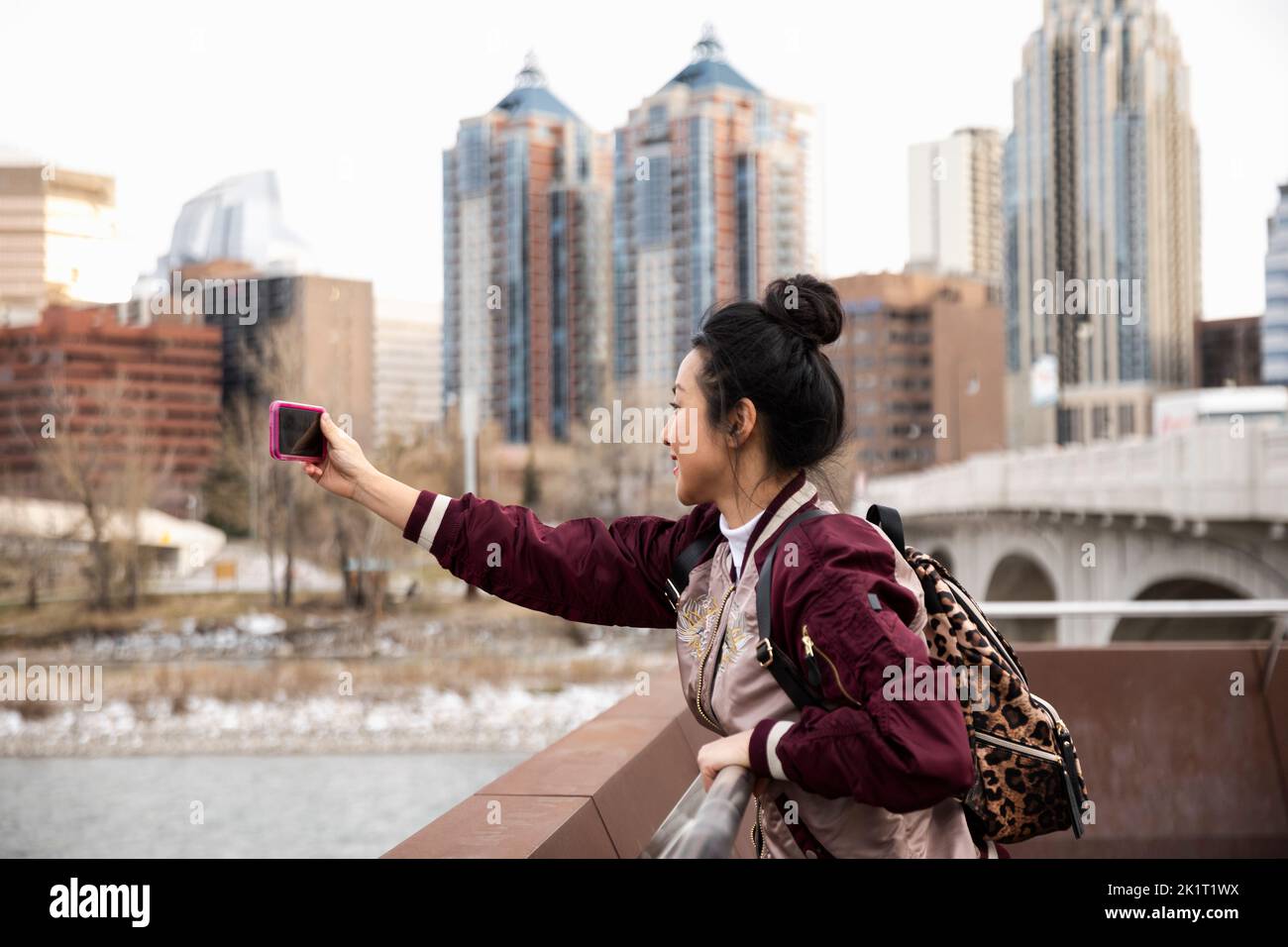 Une femme heureuse touriste qui prend un selfie avec un téléphone photo dans le parc de la ville Banque D'Images