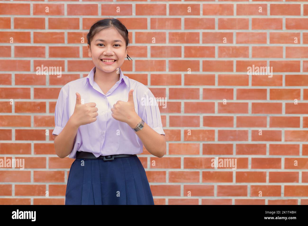 Fille d'école asiatique deux pouces vers le haut geste heureux profiter pour le bon concept d'apprentissage d'éducation Banque D'Images