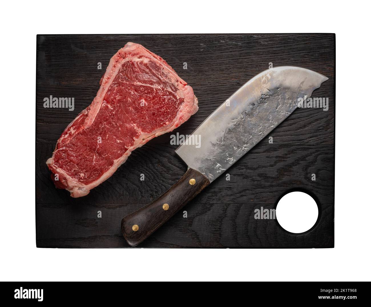 Un morceau de viande de bœuf cru juteux sur l'os repose sur une planche à découper en bois Banque D'Images