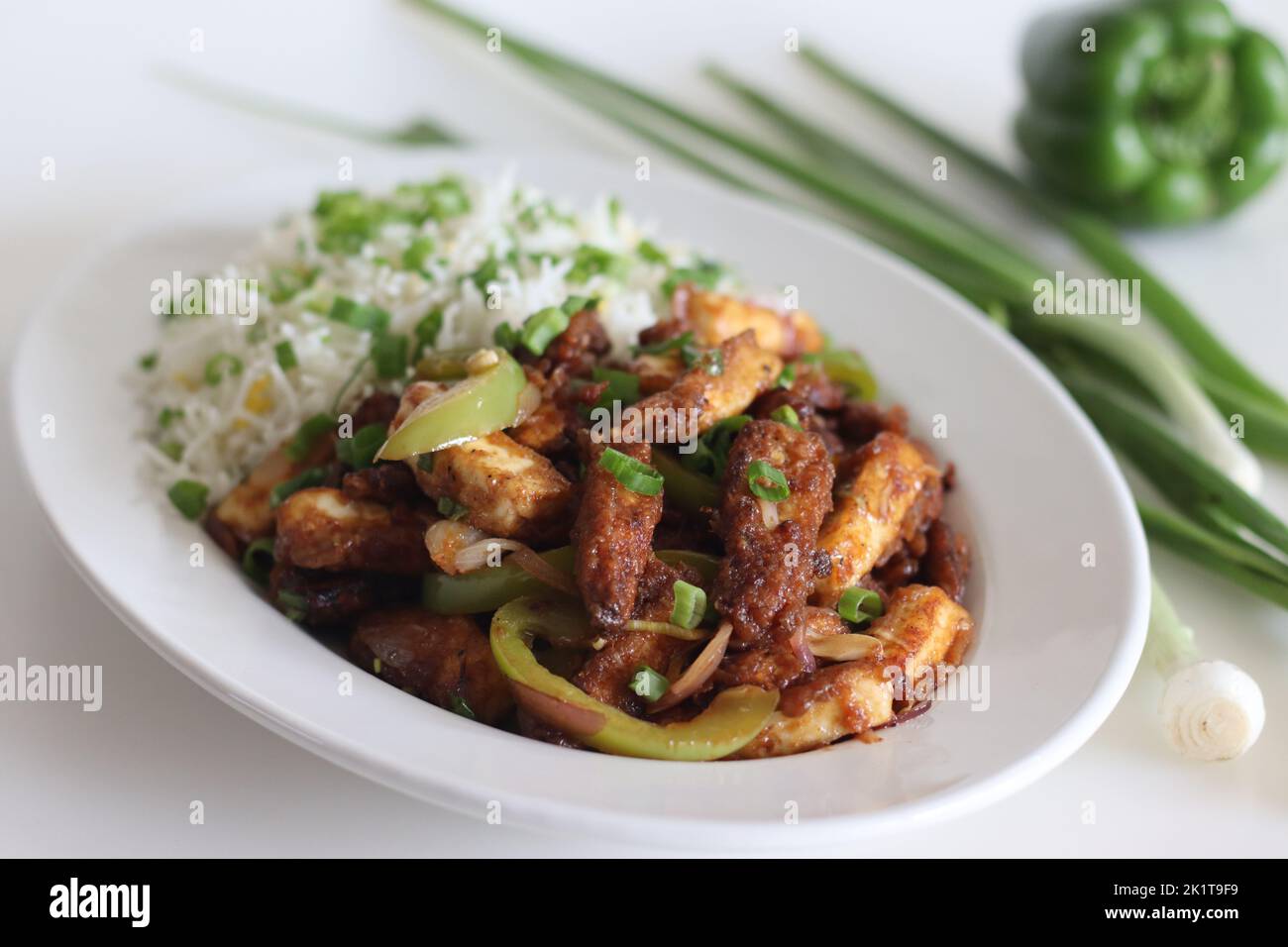 Panner maïs de bébé Manchurien. Un plat végétarien indo chinois croustillant et croustillant, dans une sauce douce avec des poivrons sautés et des oignons. Prise de vue sur b blanc Banque D'Images