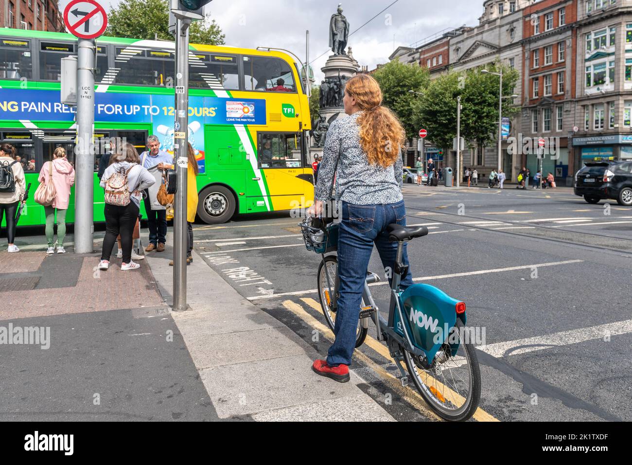Femme à louer un vélo « MAINTENANT » dans le centre-ville de Dublin, en Irlande. Banque D'Images