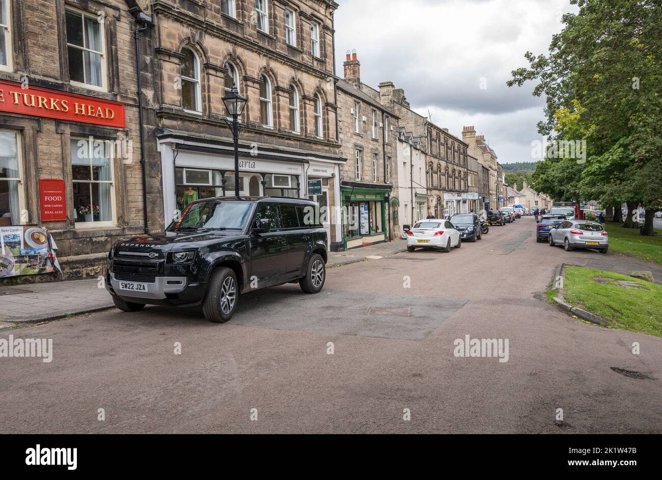 Nouveau défenseur de terrain en noir stationné sur la rue High dans la petite ville marchande de Rothbury, Northumberland, Angleterre. Banque D'Images
