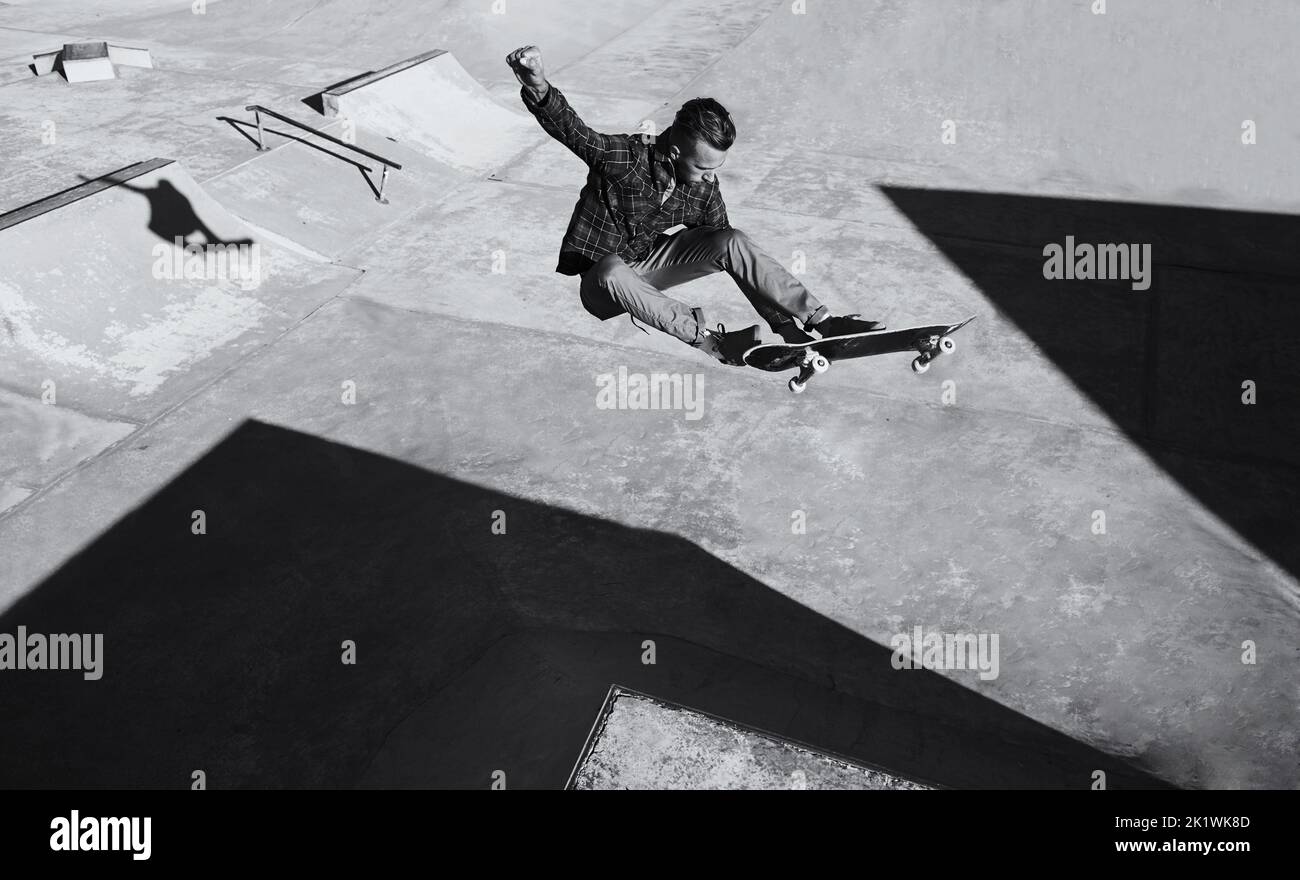 HES a des compétences. Une photo en noir et blanc d'un skateboarder qui fait des tours dans un skatepark. Banque D'Images