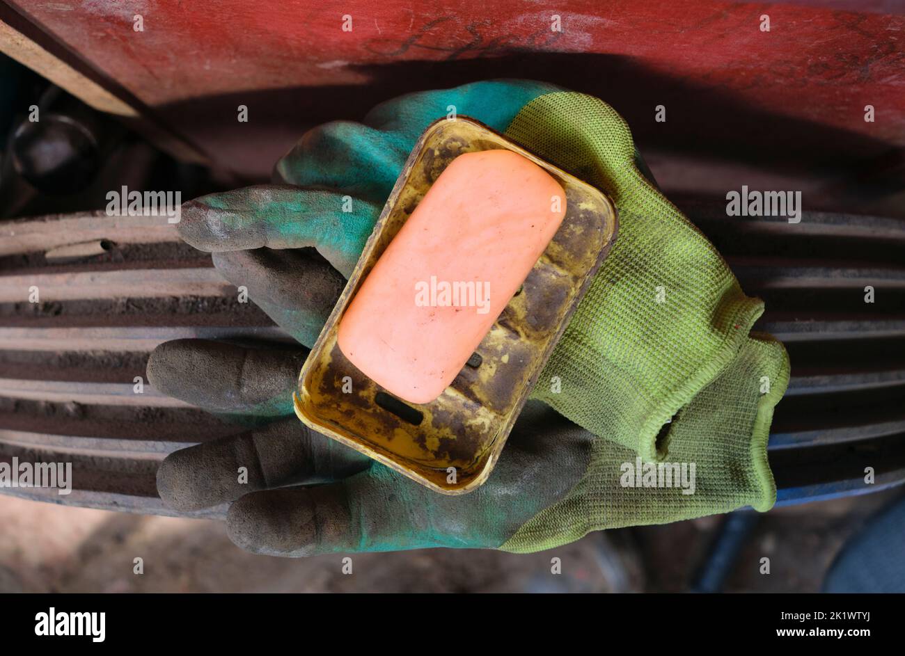 Un gros plan d'une barre de savon et de gants de travail rose, orange et saumon usagés. Au bazar Yangiobod, marché à Tachkent, Ouzbékistan. Banque D'Images