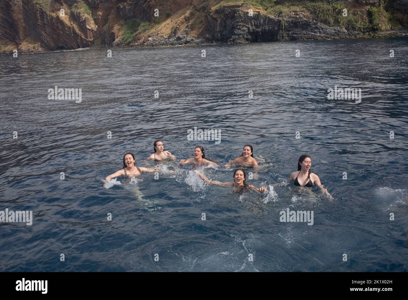 Six jeunes femmes qui profitent d'un plongeon rapide dans la baie au large de Camara de Lobos à Madère Banque D'Images