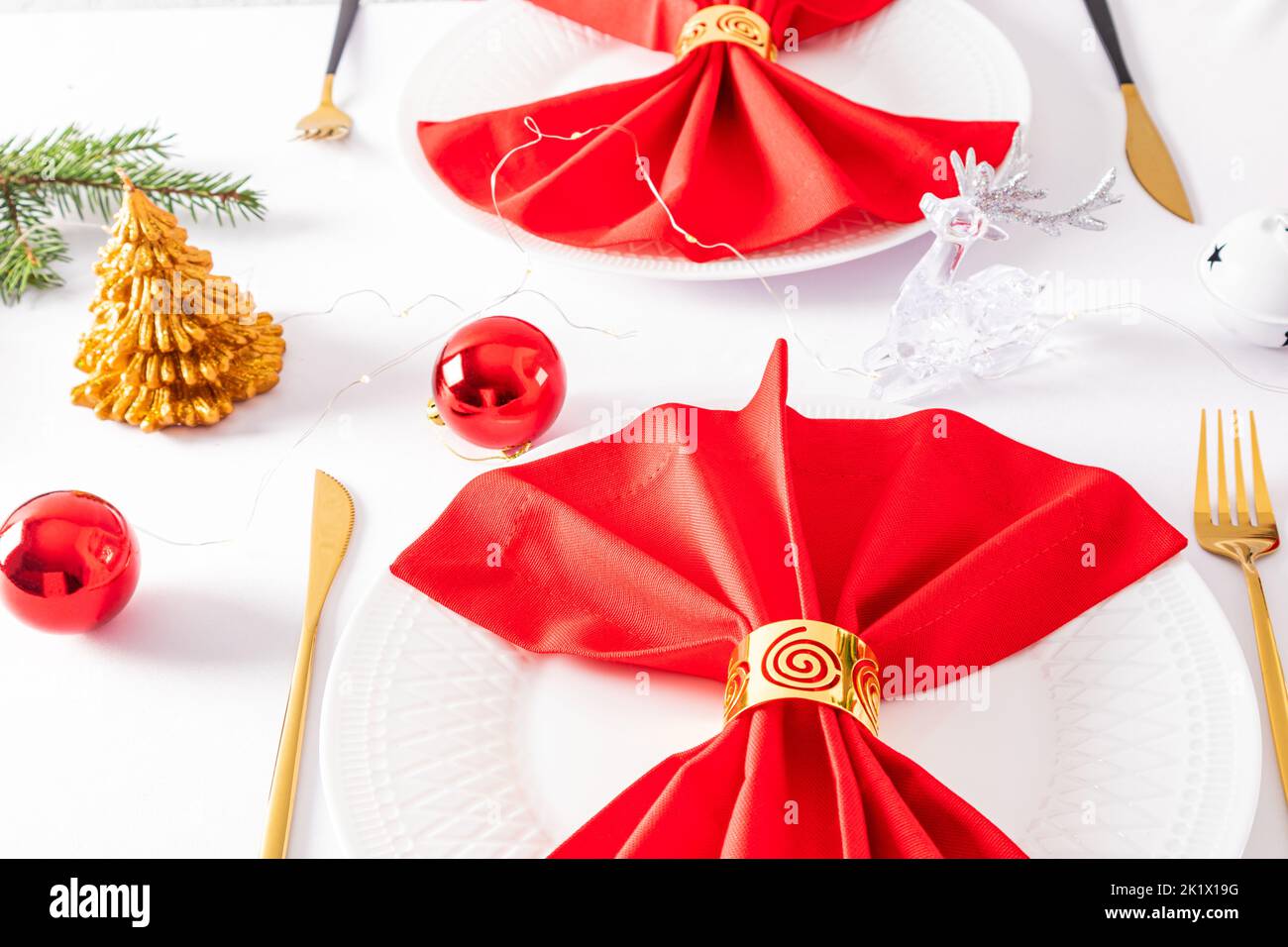 Belle décoration moderne de la table de fête. Serviettes rouges pliées en éventail avec décorations sur des assiettes blanches Banque D'Images