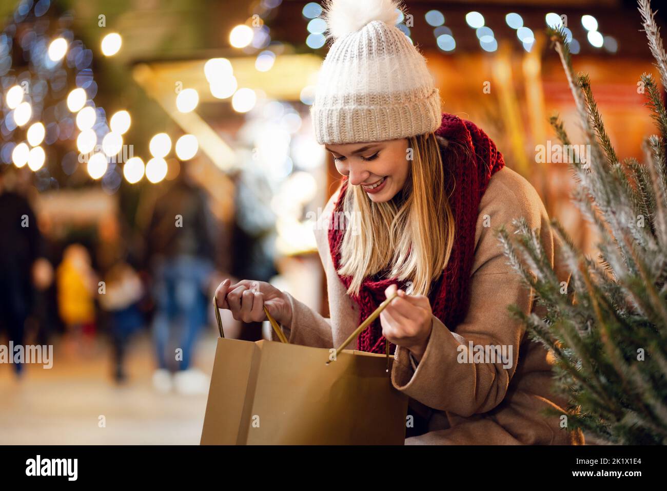 Bonne jeune belle femme choisissant le cadeau de noël et l'arbre au marché Banque D'Images