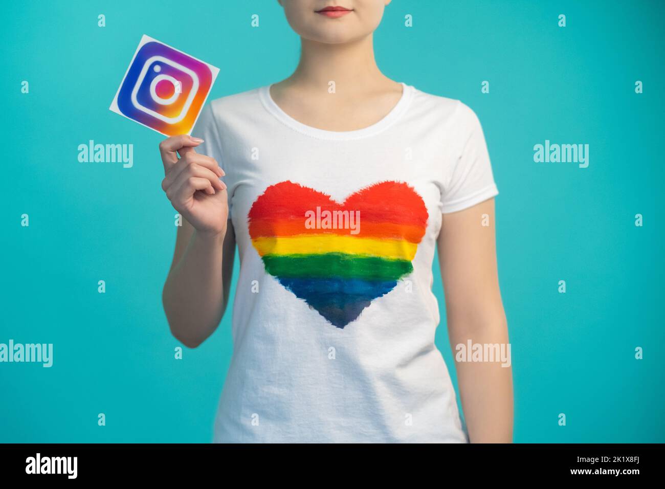 Kharkiv, Ukraine - 27 novembre 2020 : icône Instagram. Médias sociaux. Application mobile. Communauté en ligne. Femme au coeur comme un t-shirt main tenant l'application Banque D'Images