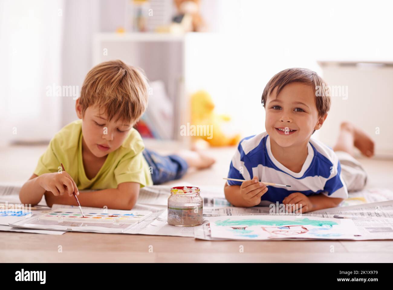 Nous adorons la peinture. Deux jeunes garçons peignent des images à la maison. Banque D'Images