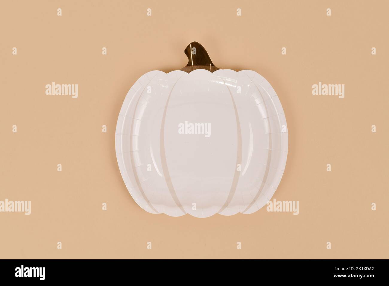 Assiette simple en papier de fête en forme de citrouille sur fond beige Banque D'Images