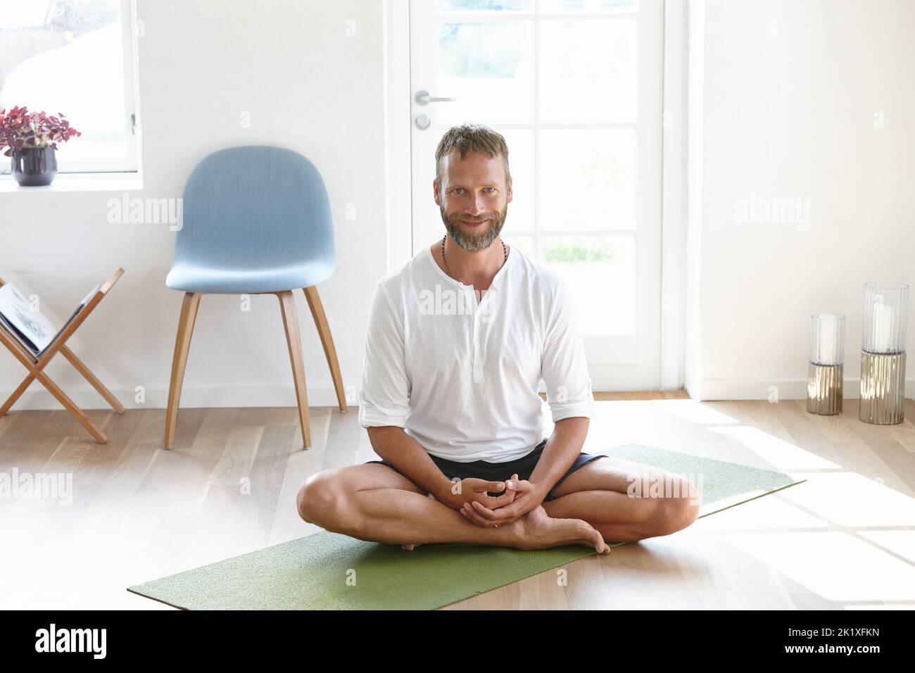 Vivre un mode de vie sain. Portrait d'un beau homme mature qui profite d'une séance de yoga à la maison. Banque D'Images