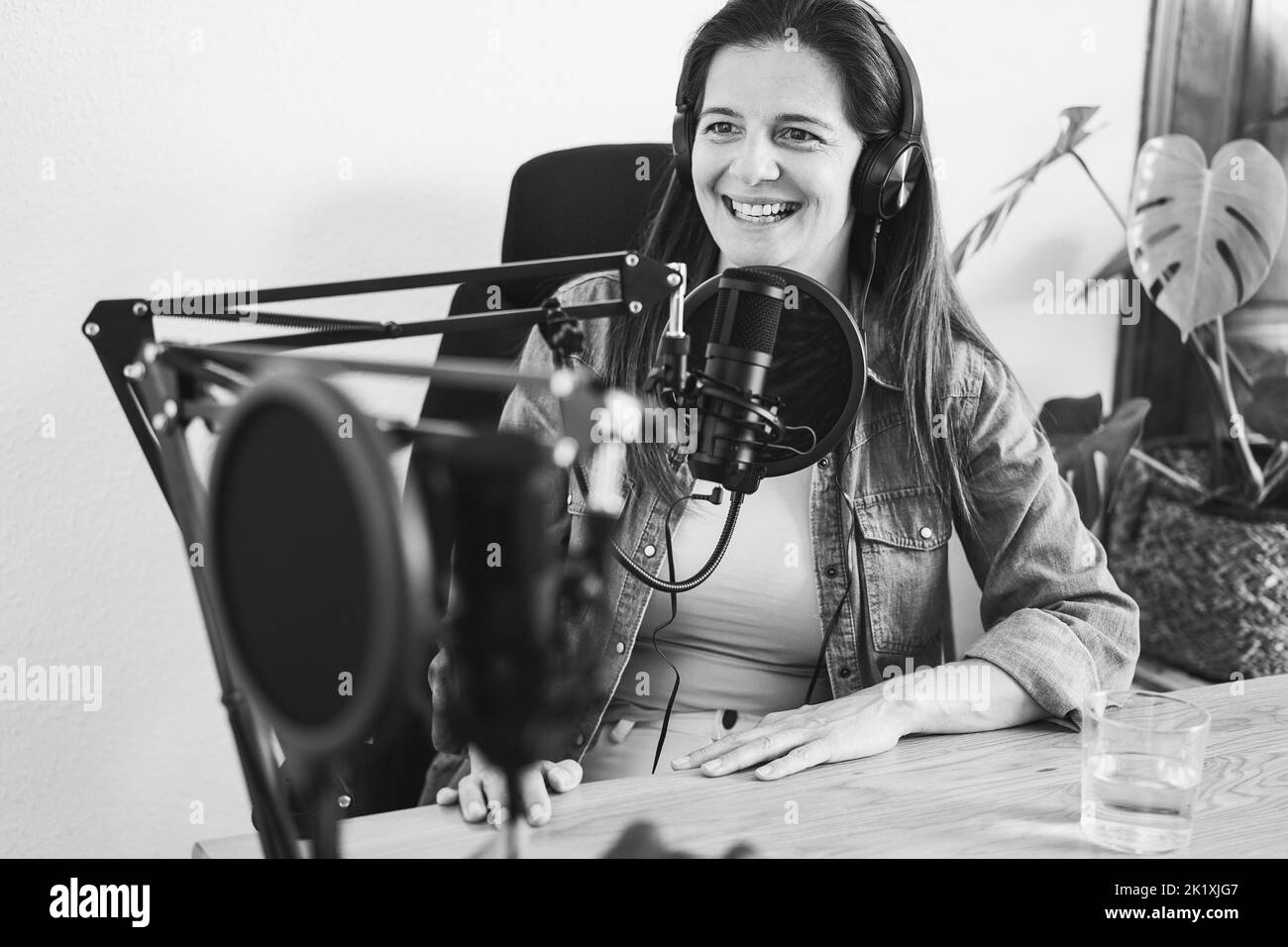 Hôtes ayant une session de podcast ensemble - intervenant féminin faisant un entretien pendant le flux en direct - montage en noir et blanc Banque D'Images
