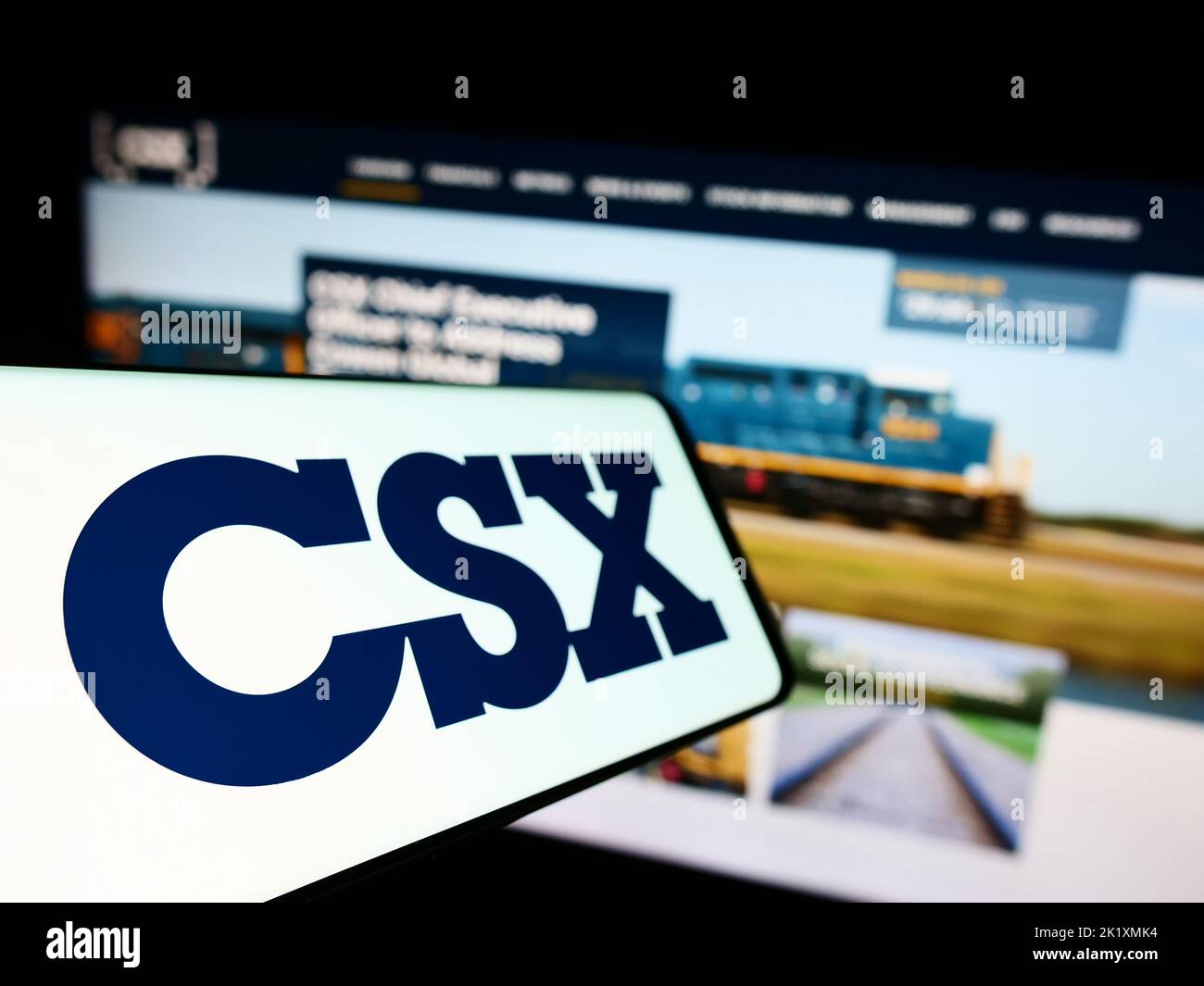 Téléphone portable avec logo de la société américaine de transport CSX Corporation à l'écran devant le site Web d'affaires. Mise au point à gauche de l'écran du téléphone. Banque D'Images