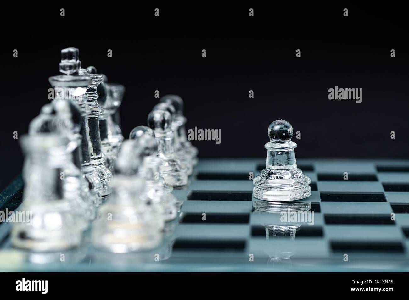 échecs en verre transparent sur fond sombre, mise au point sélective sur la pièce de pion, gros plan Banque D'Images