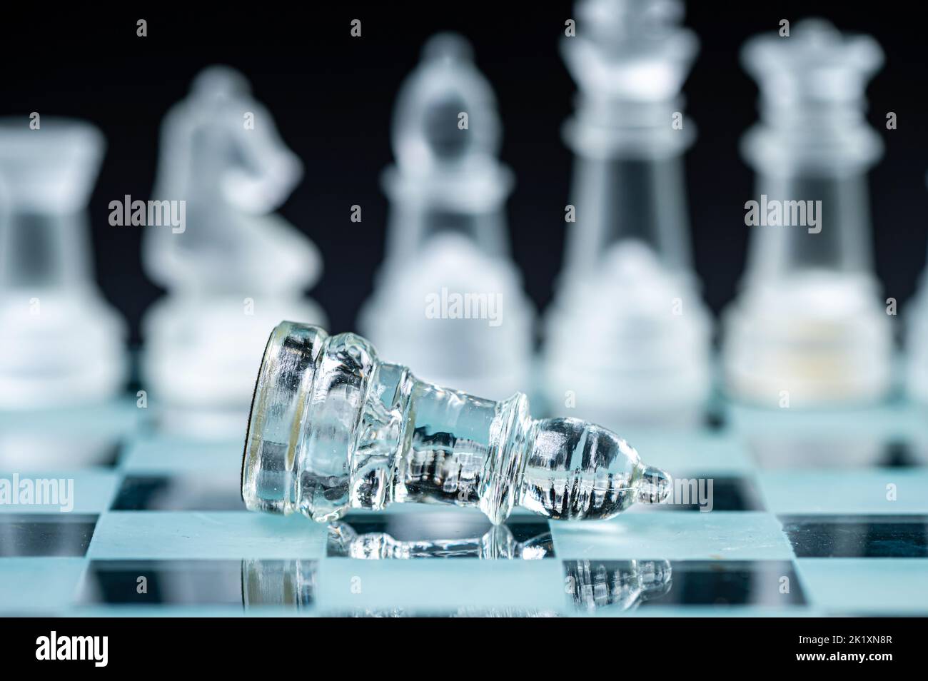 verre transparent, pièces d'échecs transparentes sur un damier, mise au point sélective, gros plan, isolé sur le noir Banque D'Images