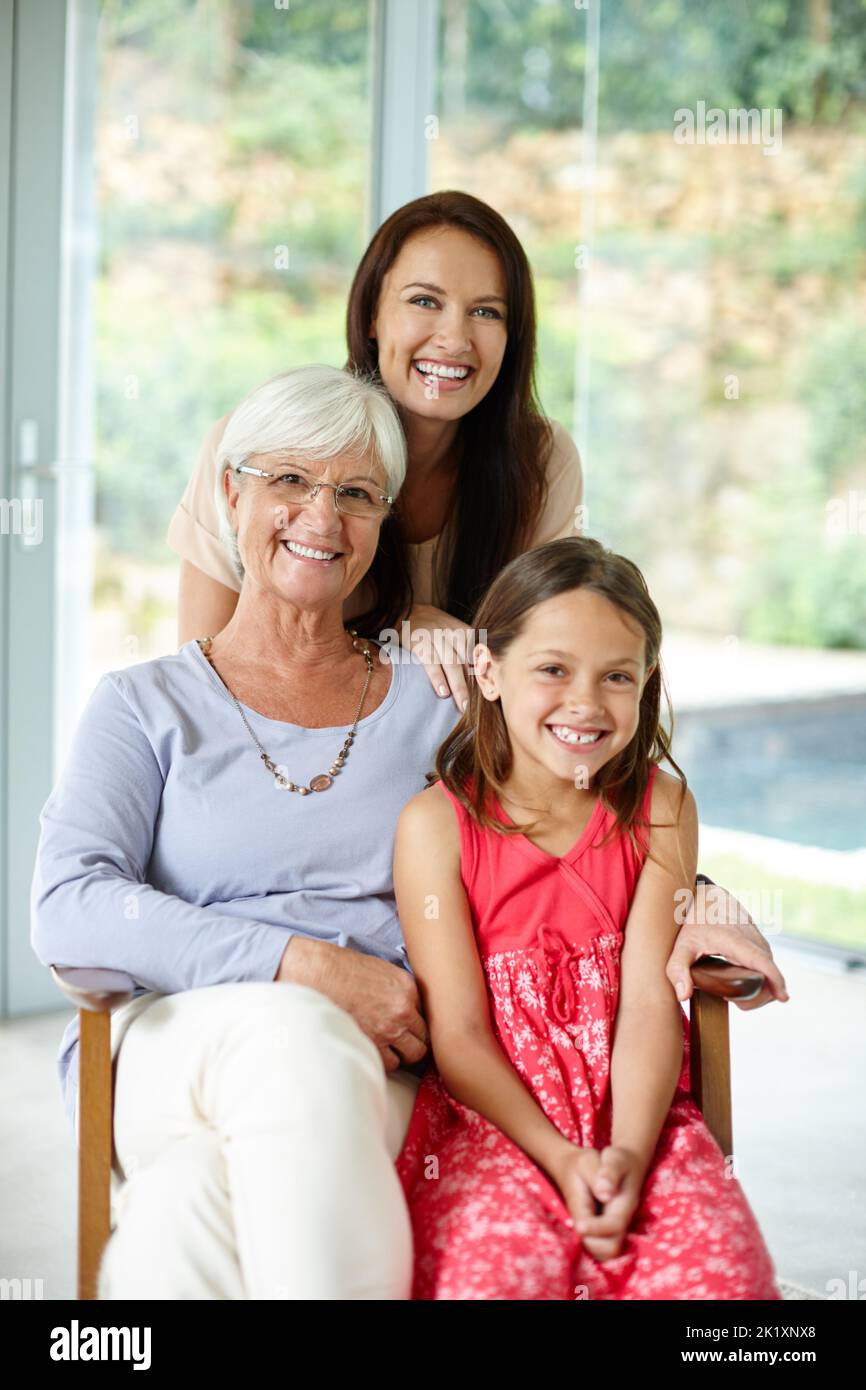 Les jolies femmes de la famille. Portrait d'une petite fille et de sa mère et de sa grand-mère assis ensemble à la maison Banque D'Images