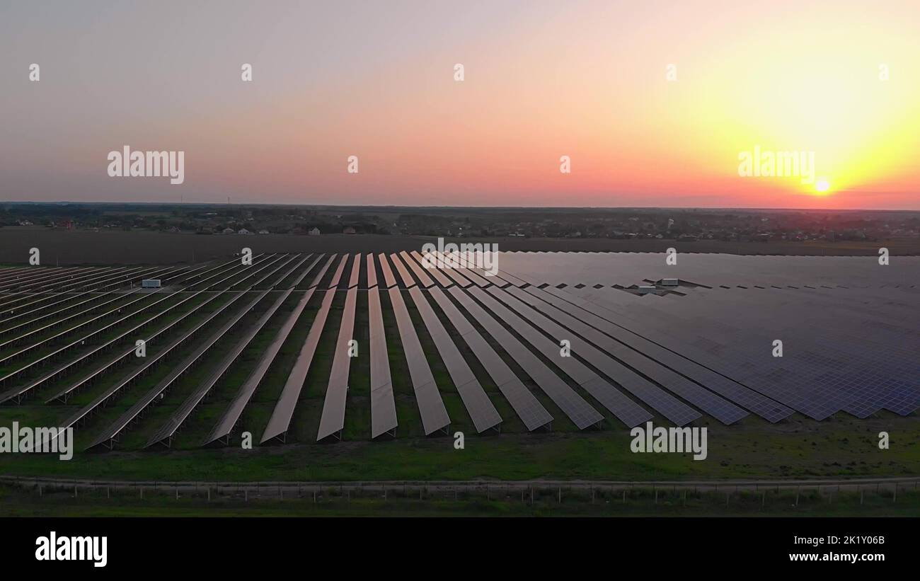 De grands panneaux solaires dans une ferme solaire au coucher du soleil d'été. Centrales solaires. Vidéo 4K, vue aérienne par drone Banque D'Images