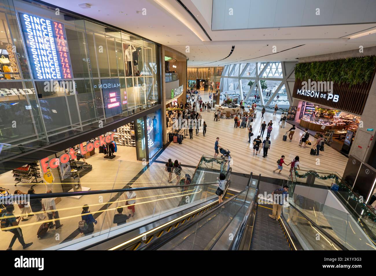 Personnes sur l'escalator dans le centre commercial de l'aéroport de Changi, Singapour Banque D'Images