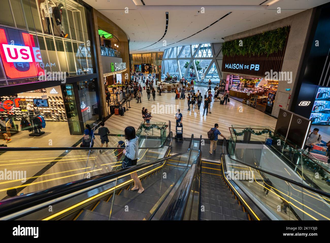 Personnes sur l'escalator dans le centre commercial de l'aéroport de Changi, Singapour Banque D'Images
