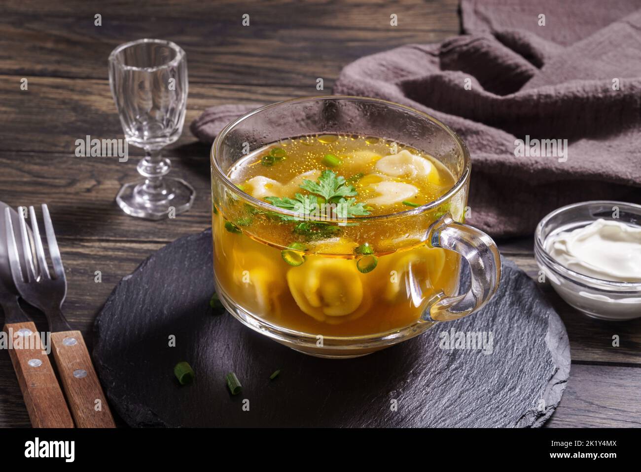 Bouillon frais avec boulettes dans un bol en verre sur la table de clôture Banque D'Images