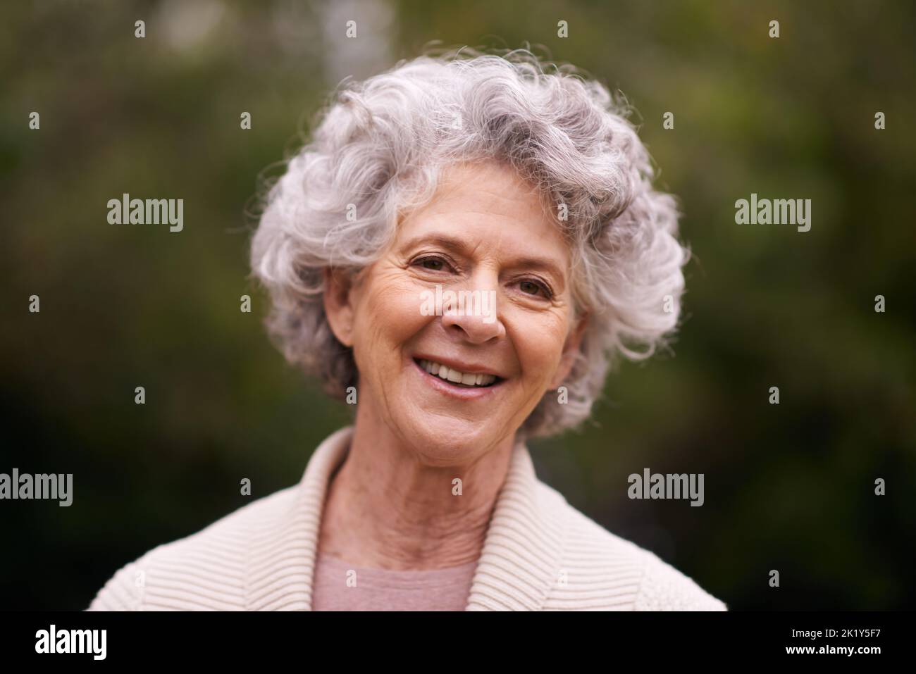 Chaque jour avec une attitude positive. Portrait d'une femme âgée debout à l'extérieur. Banque D'Images