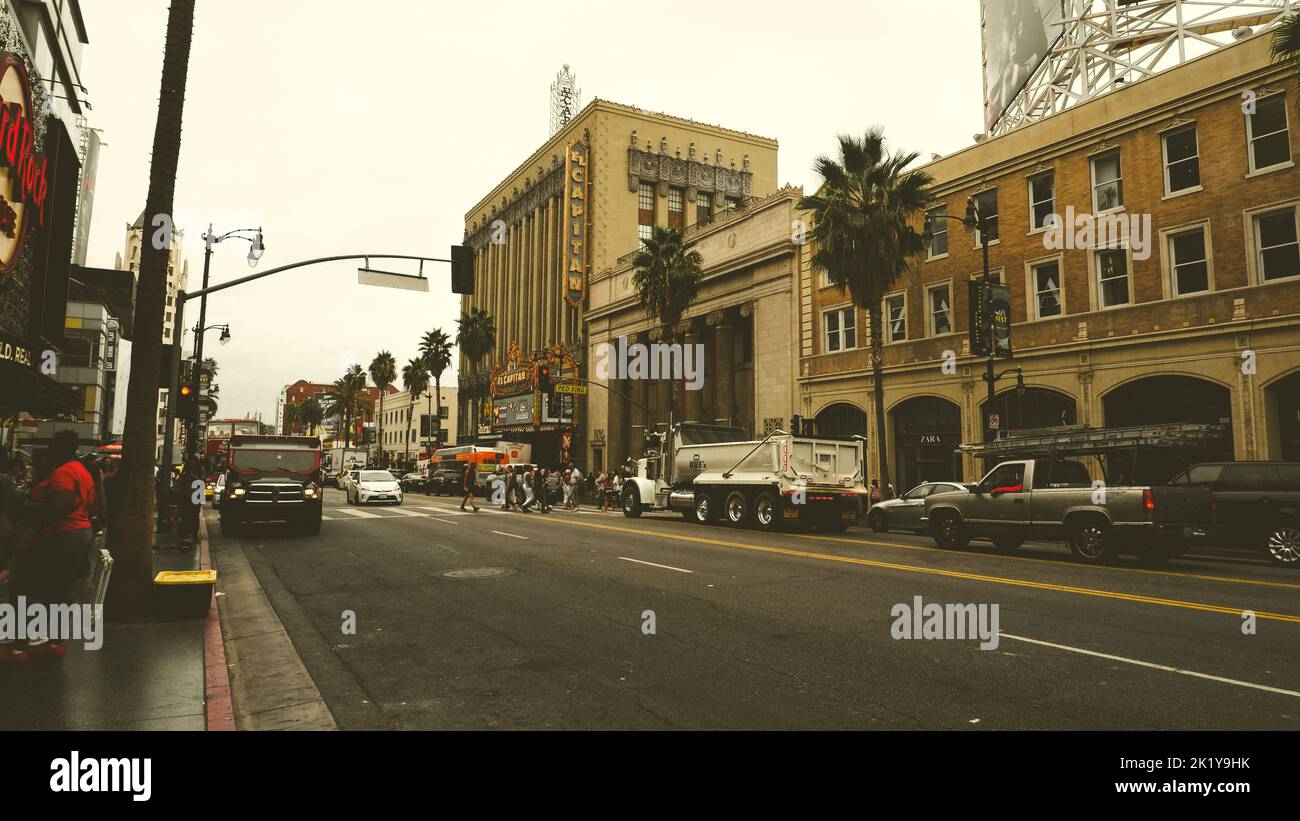 Le théâtre El Capitan sur Hollywood Boulevard avec des voitures dans la rue et des gens passant sur le trottoir Banque D'Images