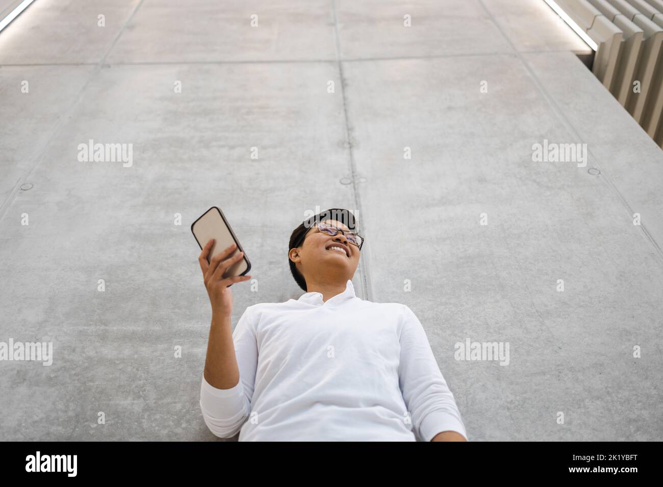 Smiling young man using mobile phone Banque D'Images