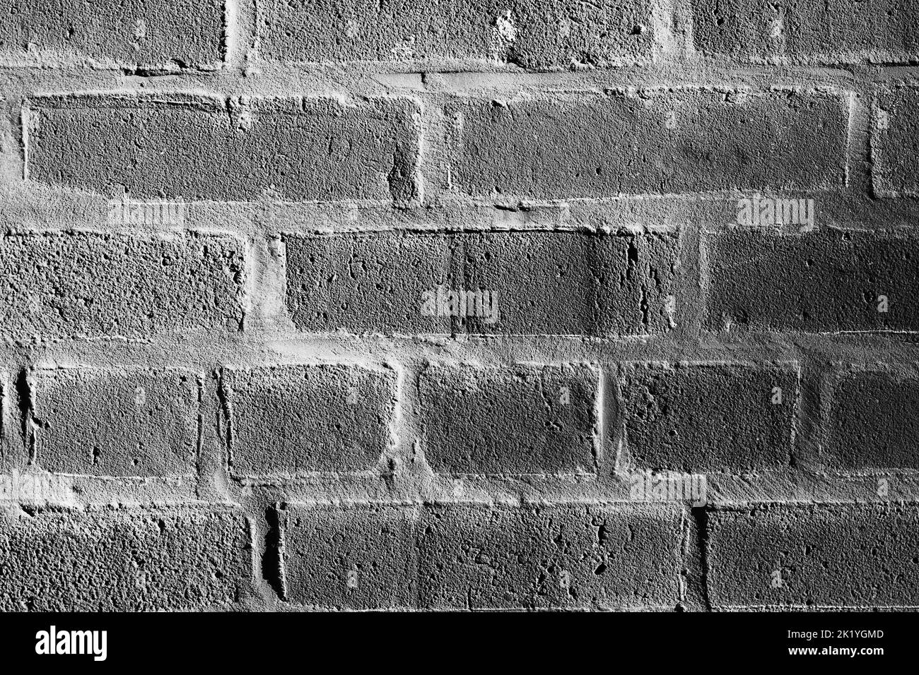 Vue plein cadre d'un mur de briques standard avec des couches de briques dans un monochrome noir et blanc. Banque D'Images