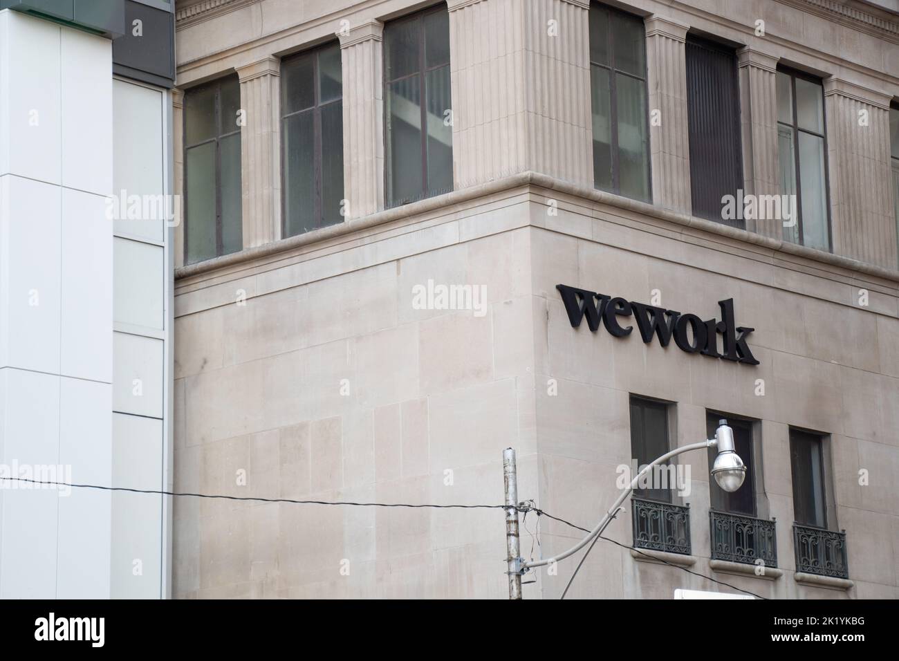 Le logo WeWork se trouve sur le côté d'un immeuble de bureaux au centre-ville de Toronto; WeWork est un fournisseur d'espaces de travail pour les collègues. Banque D'Images