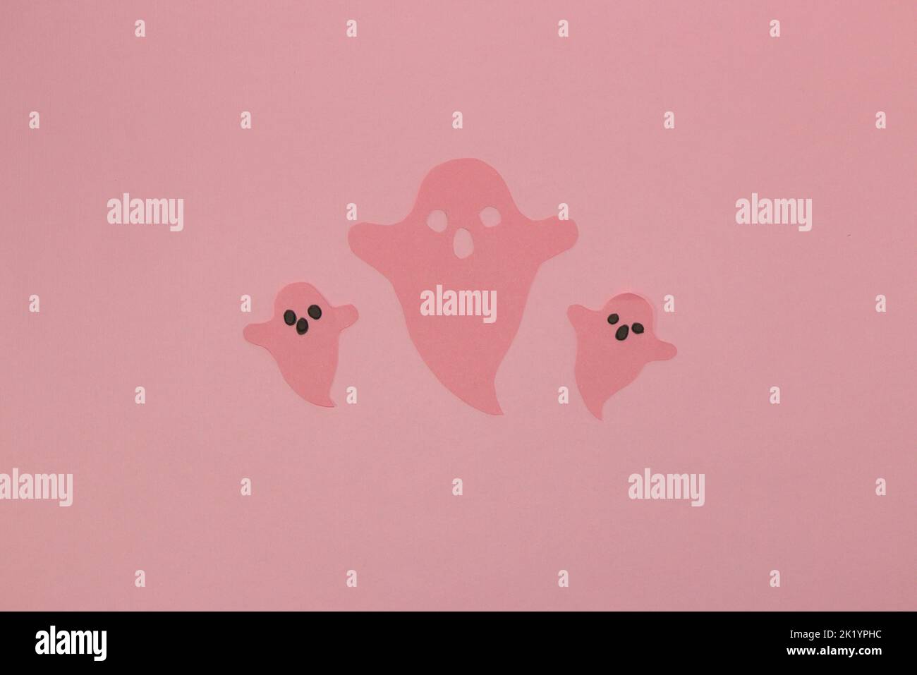 fantômes roses sur fond rose, design artistique créatif, concept halloween minimal, pose à plat Banque D'Images