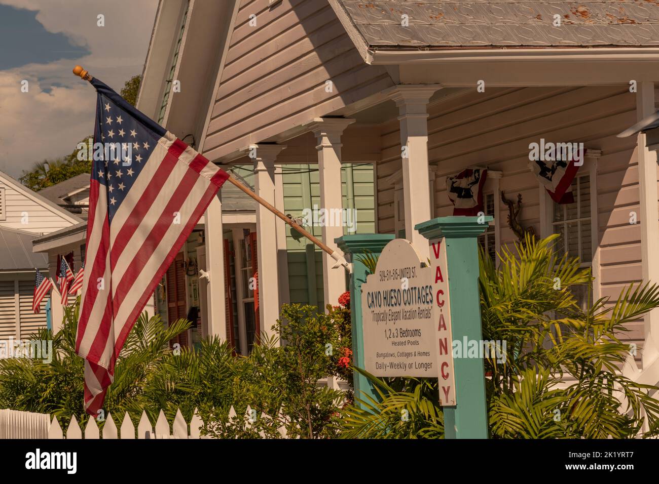 Une maison traditionnelle de la ville de Key West dans un style des Caraïbes avec des clôtures blanches et le drapeau des États-Unis. Banque D'Images