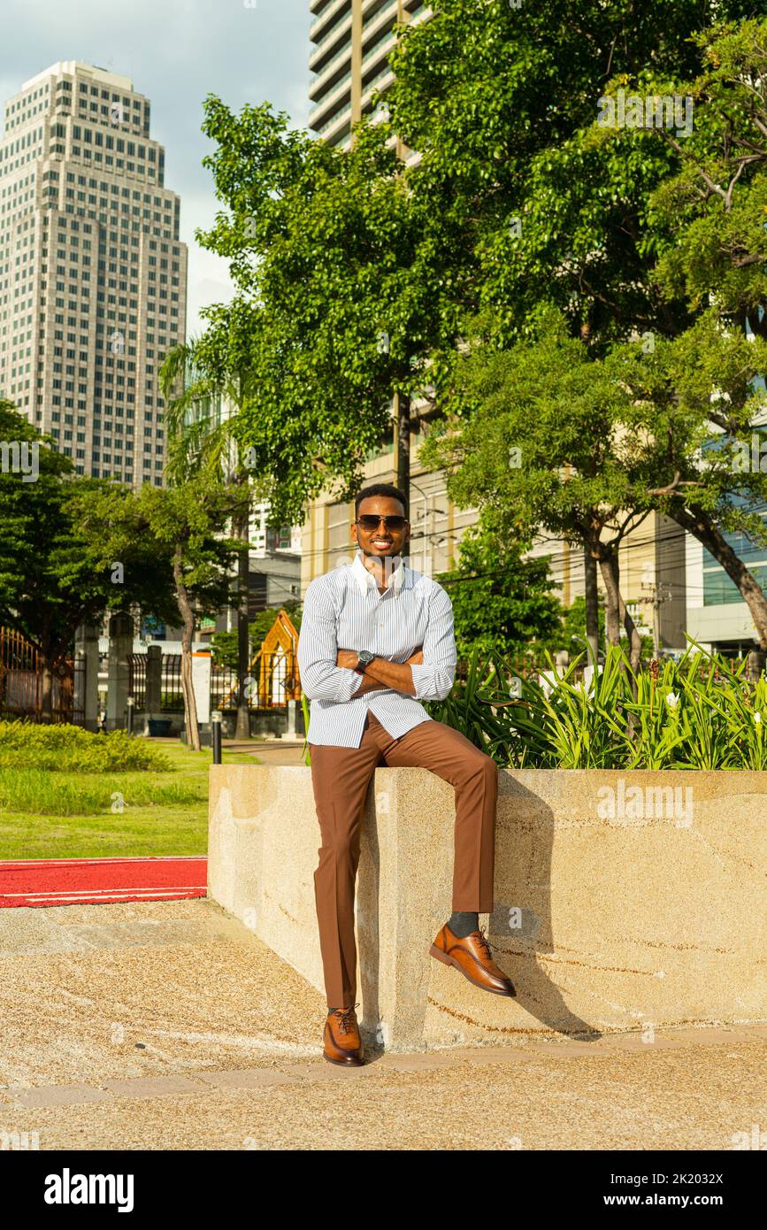 Portrait de beau jeune homme d'affaires noir au parc à l'extérieur pendant l'été Banque D'Images