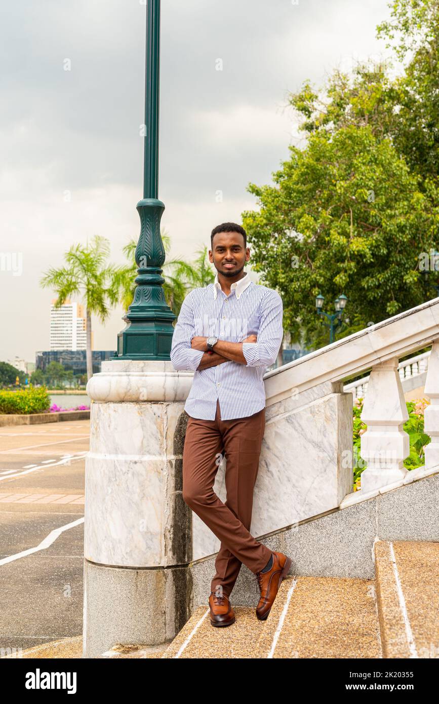 Portrait de beau jeune homme d'affaires noir au parc à l'extérieur pendant l'été Banque D'Images