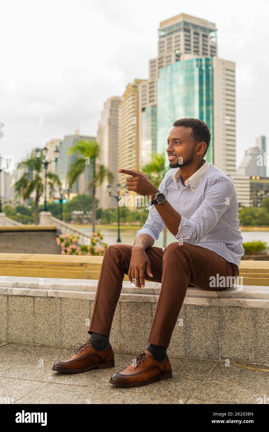 Portrait de beau jeune homme d'affaires noir au parc à l'extérieur pendant l'été Banque D'Images