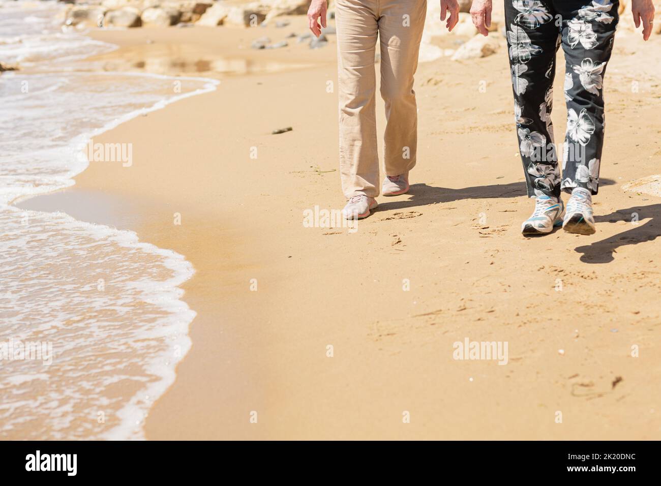 Deux femmes âgées méconnues marchant le long de la mer rocheuse Banque D'Images