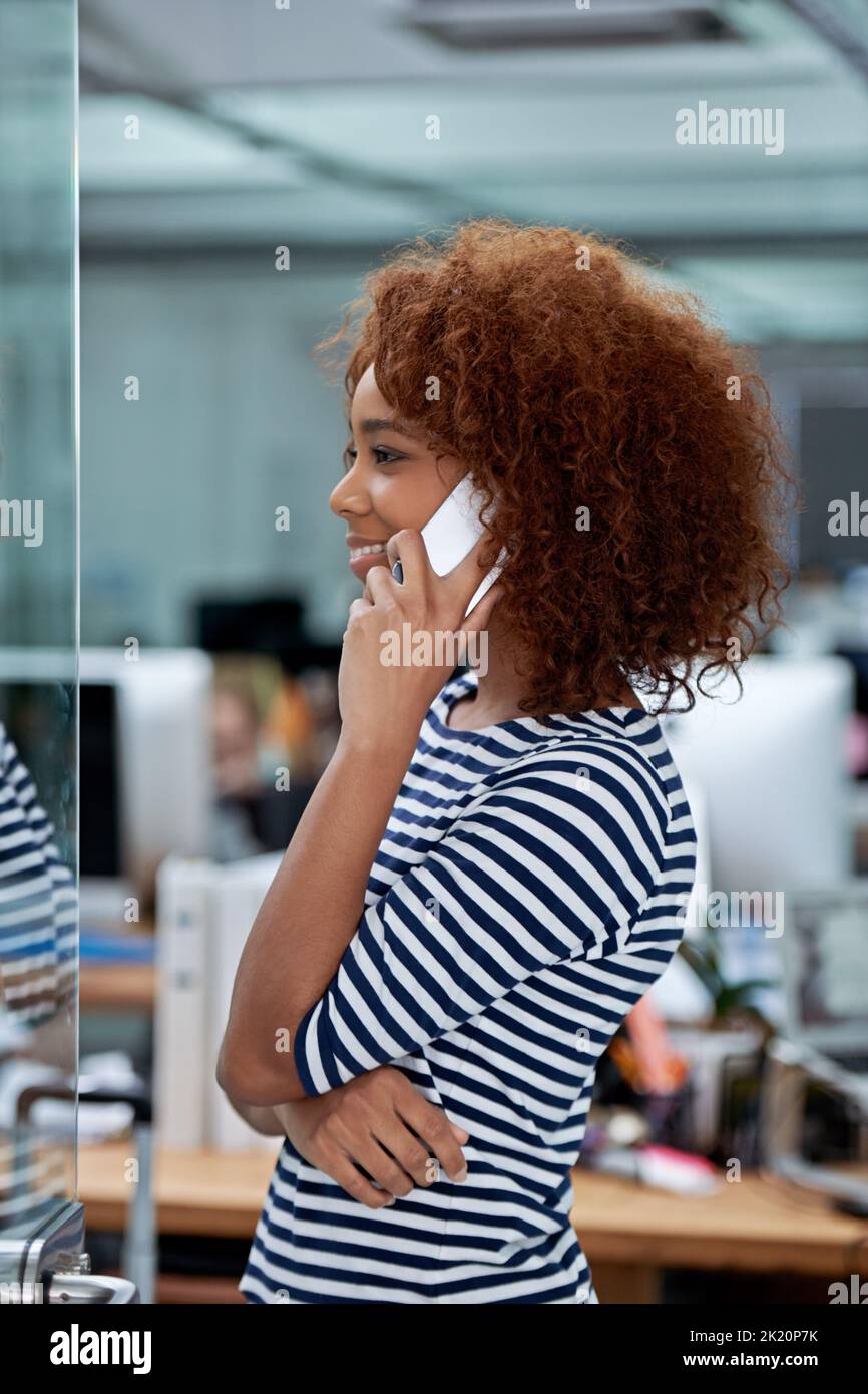 Je suis malade dans mon bureau jusqu'en 5. Une jeune femme parlant au téléphone dans un bureau Banque D'Images