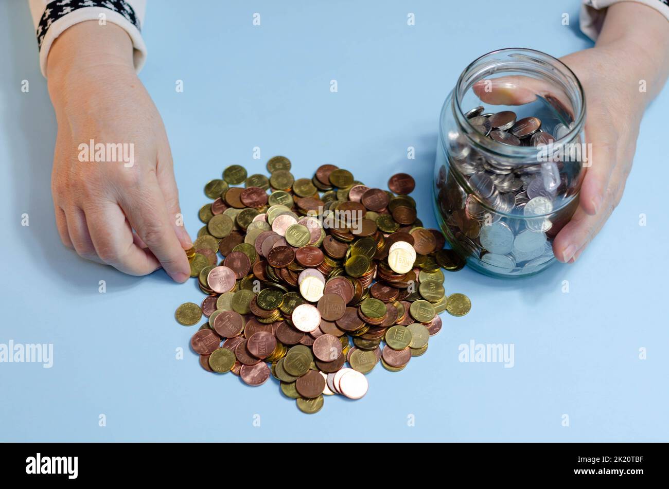 Femme âgée comptant des pièces de monnaie sur la table. Gros plan sur les billets de banque lei roumains Banque D'Images