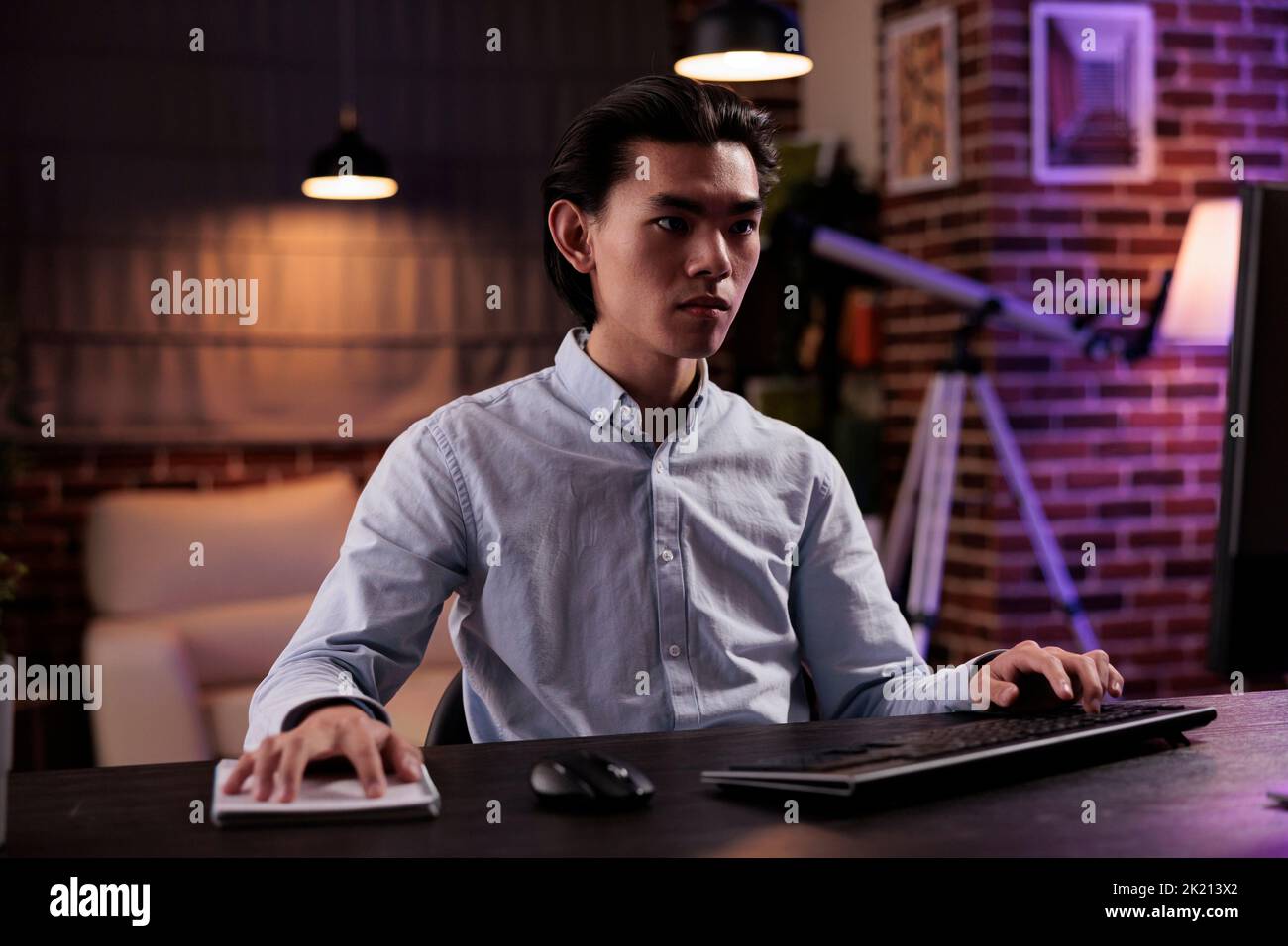 Indépendant de sexe masculin faisant du travail à distance sur ordinateur, assistant à une leçon en ligne à la maison. Travailler à distance sur les rapports d'entreprise avec plan de données de recherche et informations, en envoyant des e-mails sur le site Web. Banque D'Images