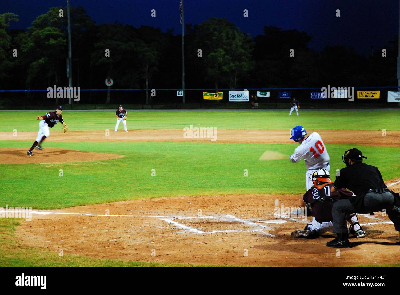 Un batter prend un swing sur un terrain lors d'un match de nuit dans la ligue de baseball de Cape Cod, l'un des meilleurs pour présenter des plyers de colligate en Amérique Banque D'Images