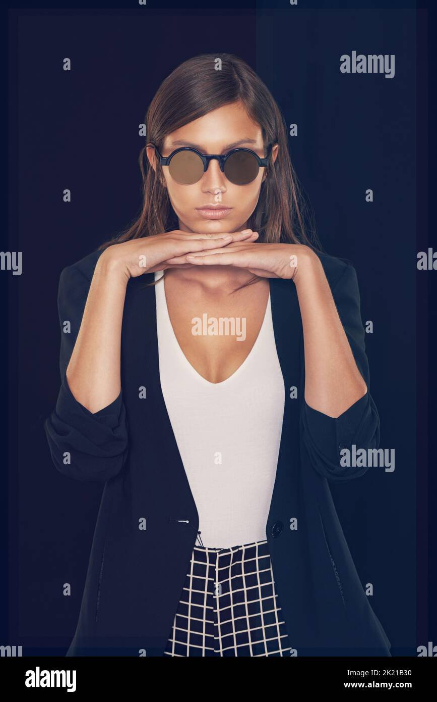 Ses a un style qui lui est propre. Court studio photo d'une belle jeune femme avec sa tête sur les mains Banque D'Images