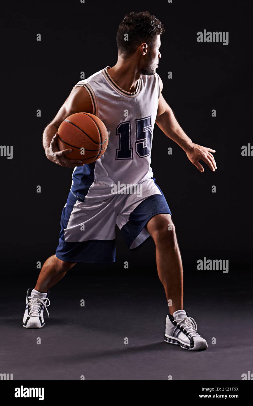 Prendre tous les comers. Photo studio d'un joueur de basket-ball sur fond noir Banque D'Images