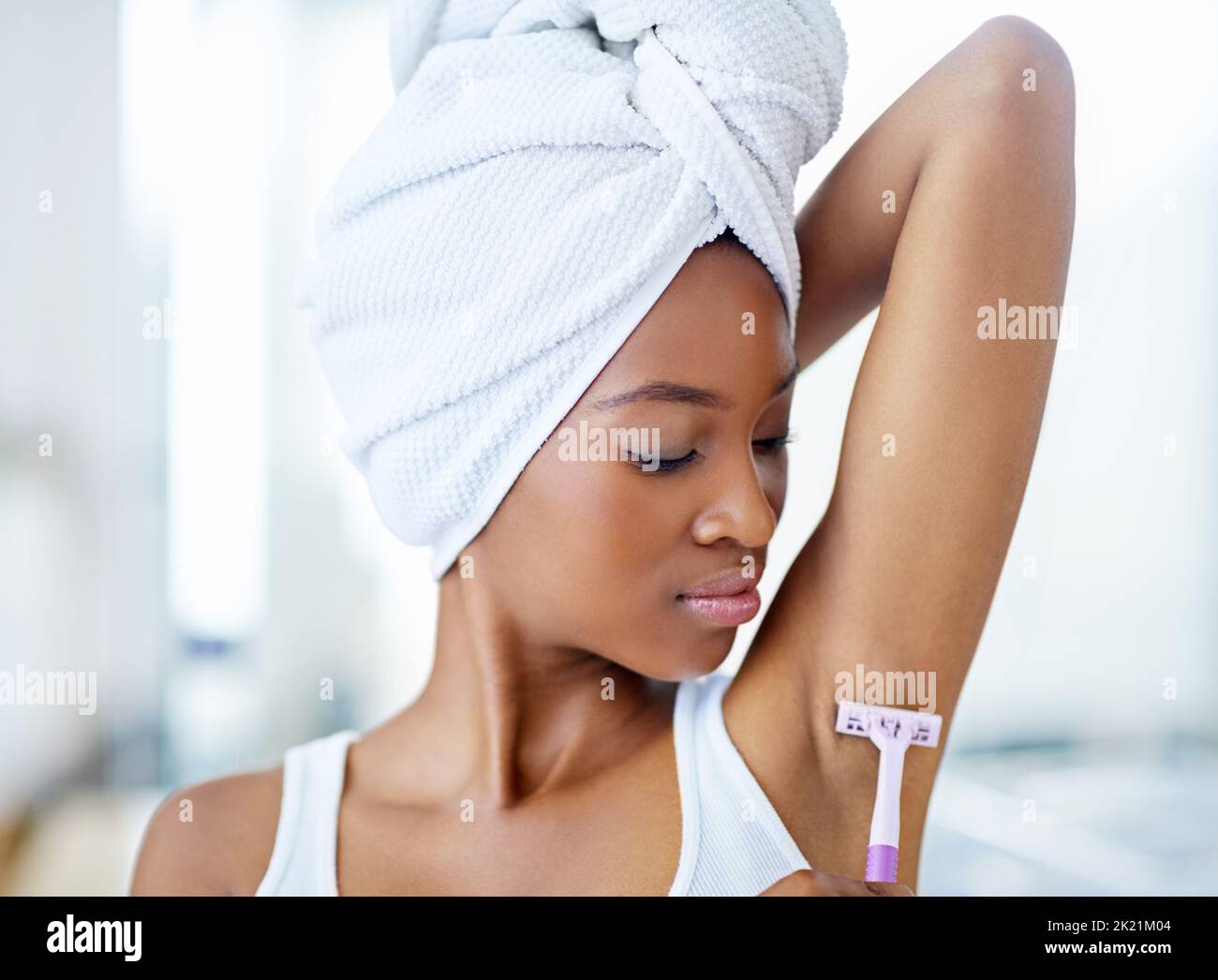 Le rasage le plus proche de loin. Une belle jeune femme pendant sa routine de beauté quotidienne. Banque D'Images