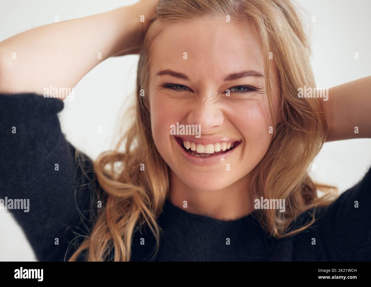 Laissez vos cheveux tomber. Portrait d'une belle jeune femme avec ses mains sur la tête Banque D'Images