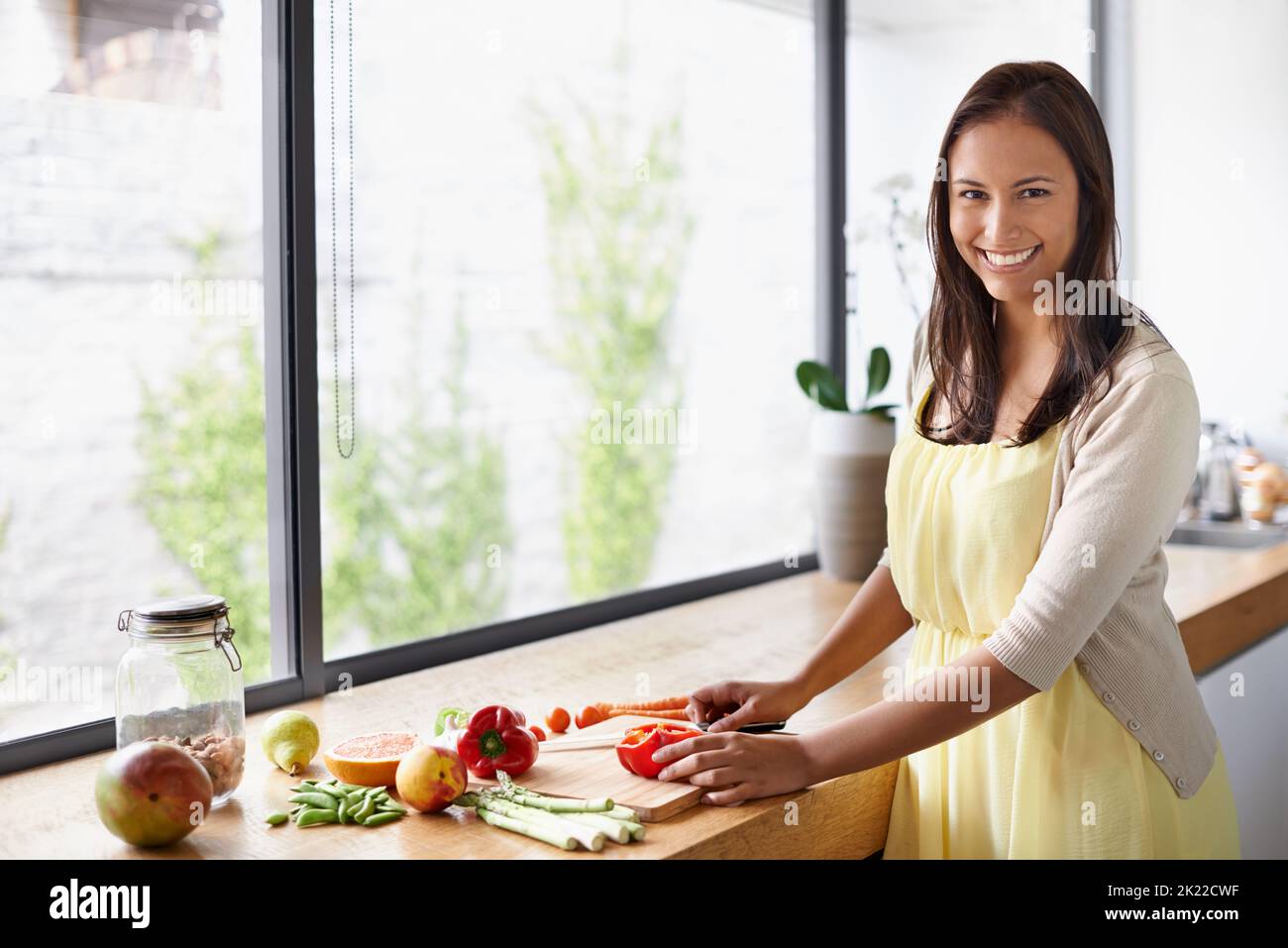 Préparer une salade fraîche. Une jeune femme prépare de la nourriture dans sa cuisine Banque D'Images
