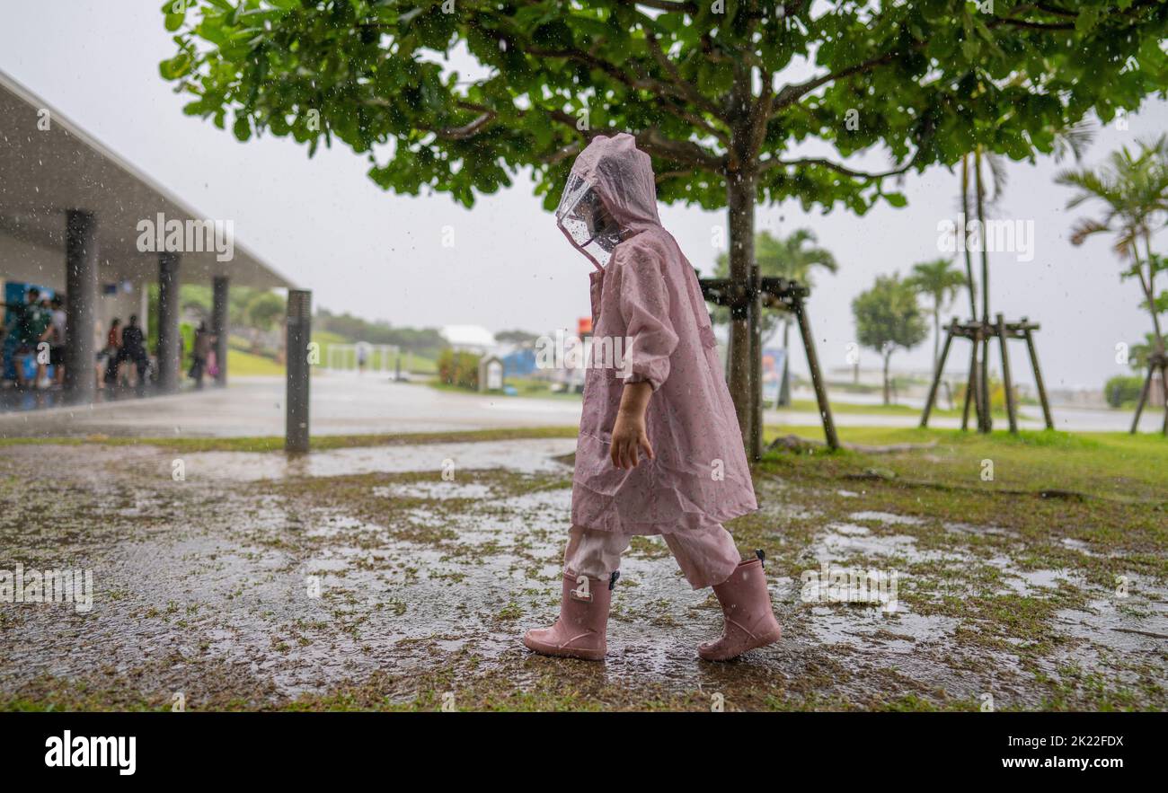 4 ans sous la pluie pendant le typhon à Okinawa. Banque D'Images