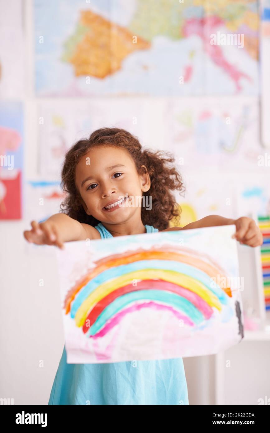 Vous n'aimez pas les couleurs. Une petite fille tenant une image qu'elle peint d'un arc-en-ciel. Banque D'Images