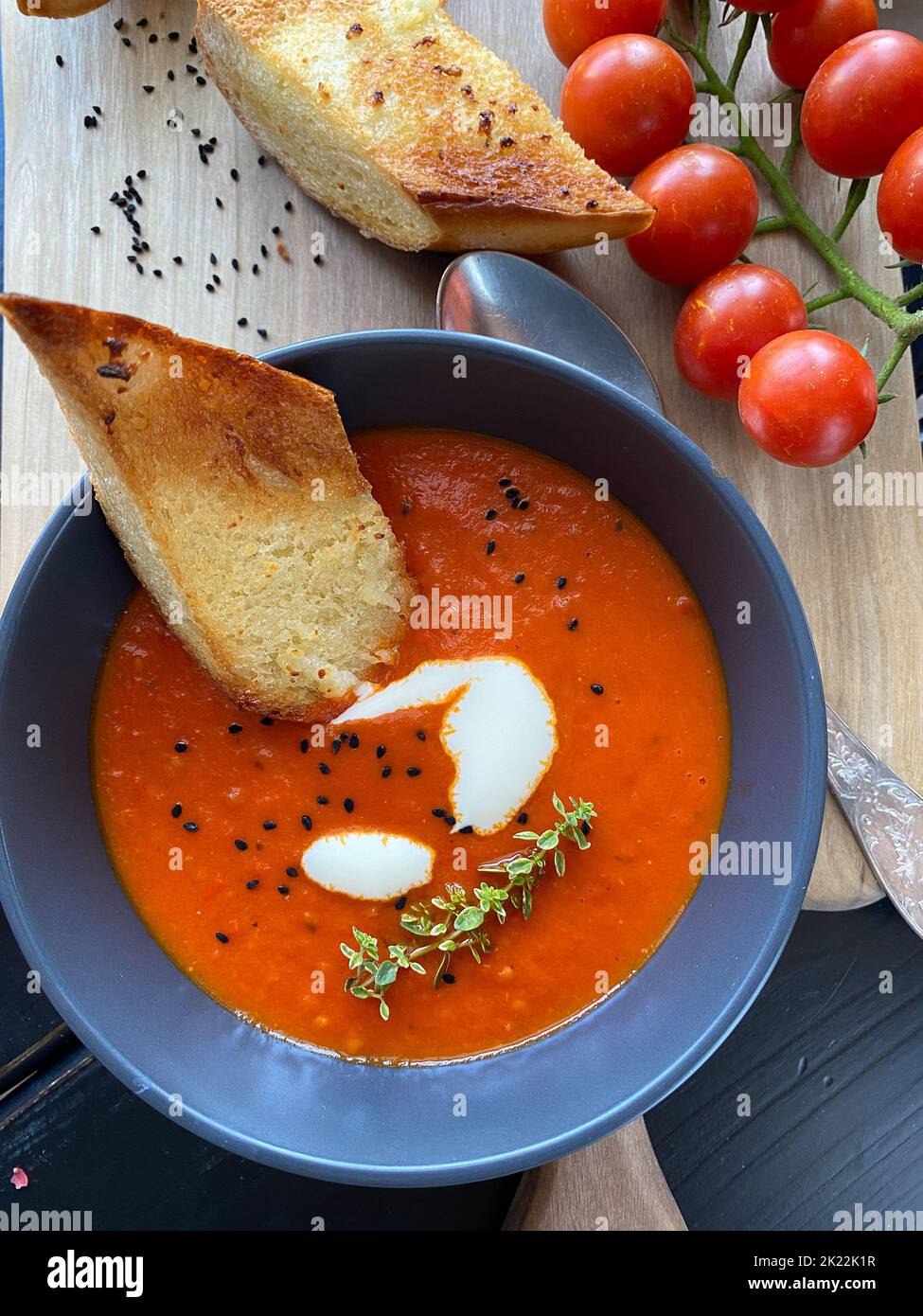 Soupe de tomates avec thym dans un bol. Arrière-plan sombre. Gros plan. Vue de dessus. Image verticale Banque D'Images