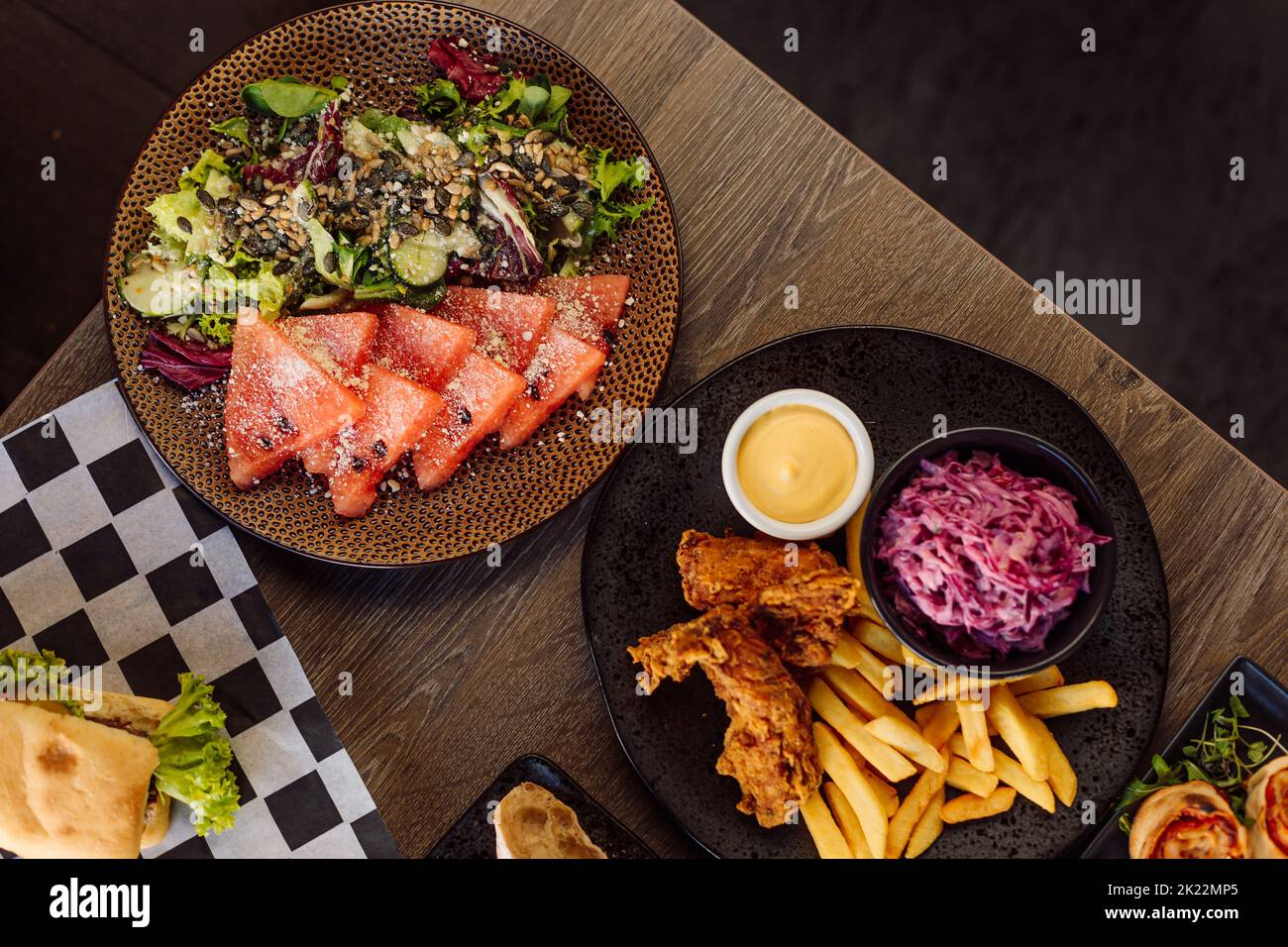 Menu du café et assortiment de plats. Salade de poisson sashimi au saumon, légumes sur l'assiette et poulet rôti aux frites Banque D'Images